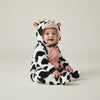 Twinkles baby wearing a cozy black and white cow-patterned polar fleece jumpsuit with a hooded animal face design.