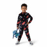 A young boy wearing a Twinkles black fleece pajama set with Lightning McQueen prints, holding a blue Stitch plush toy.