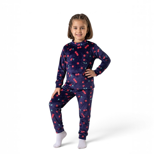 Young girl wearing a Twinkles navy blue velvet pajama set with a red cherry print pattern.
